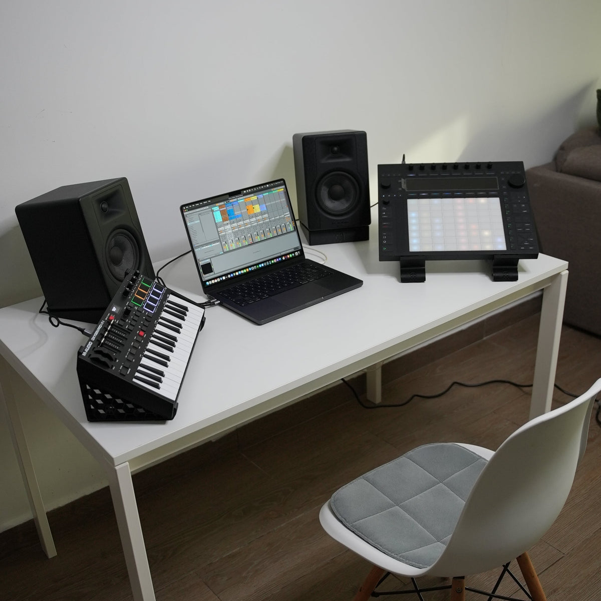 Home studio desk setup with laptop, speakers, and controller raised on Deckra stands